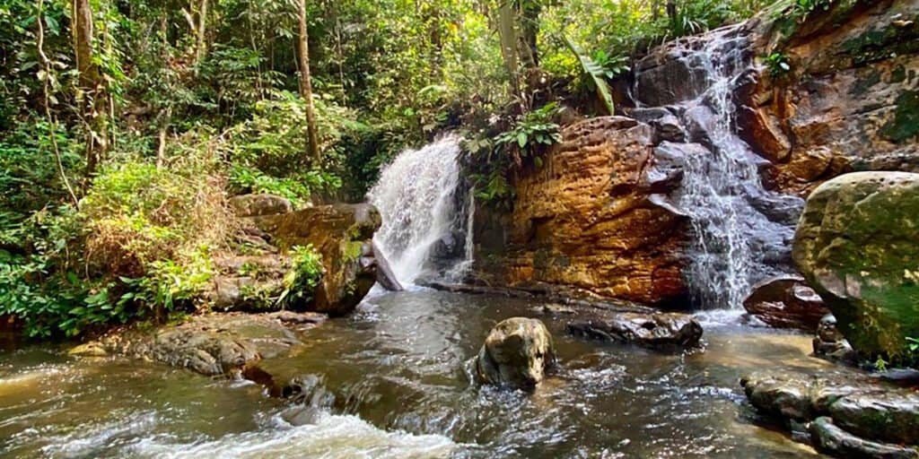 Cachoeira da Onça em Presidente Figueiredo, com quedas d’água cercadas por rochas e vegetação densa da floresta amazônica.